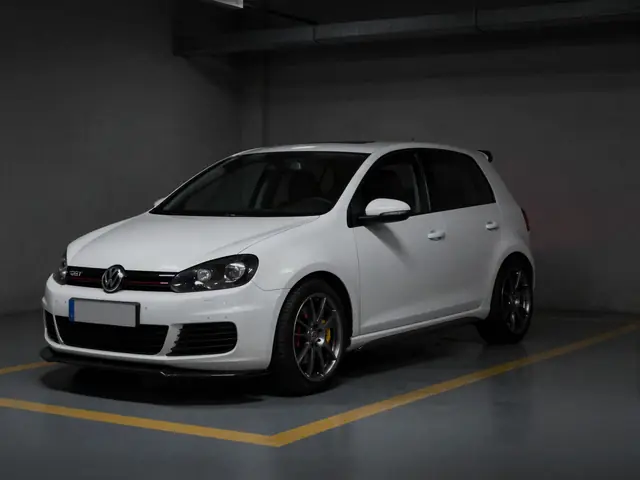 Volkswagen Golf VI GTI branco com kit ABT numa garagem